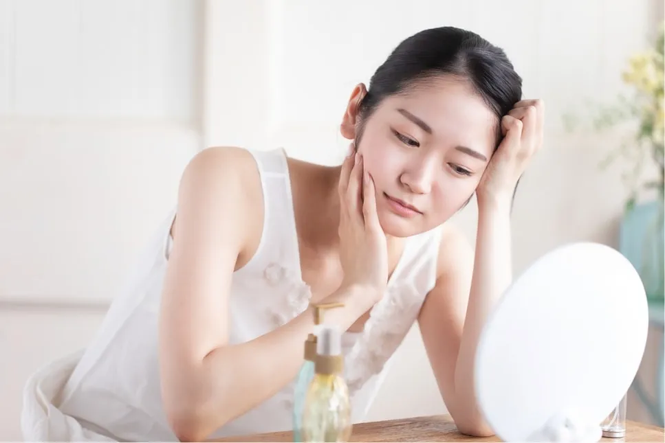 女性が鏡を見ながら悩んでいる様子